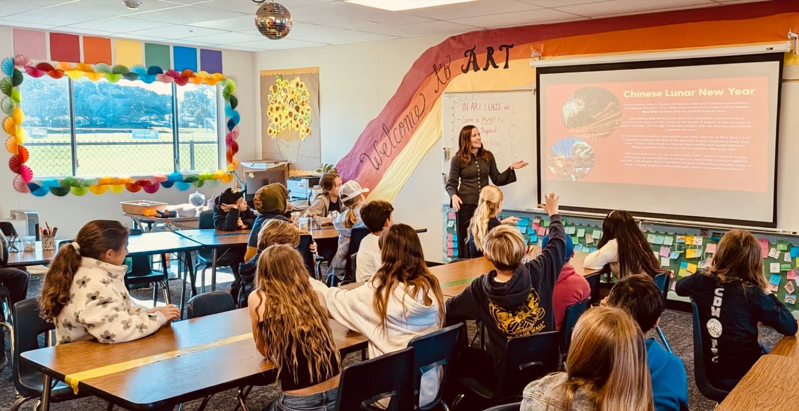 Students raising their hands during a Chinese Lunar New Year art lesson in the Eastbluff studio