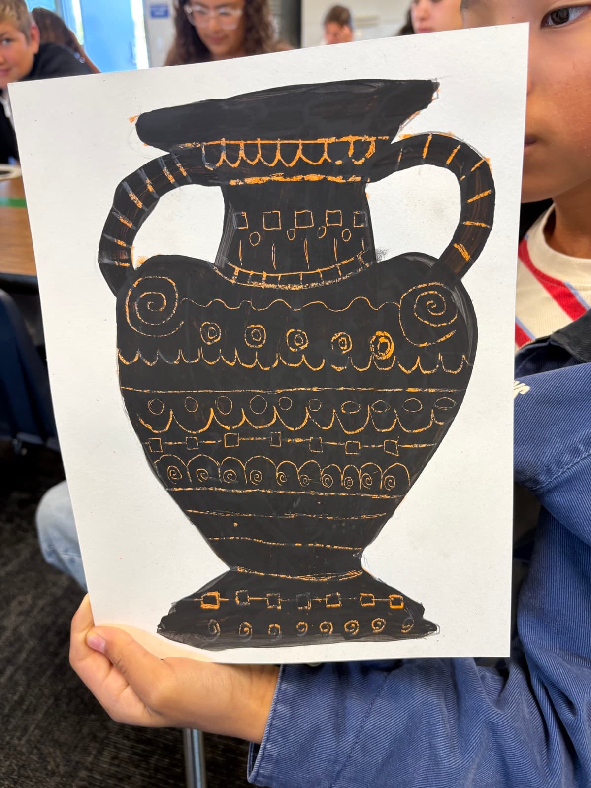 Eastbluff student holding up their Greek-style vase painting in the art studio