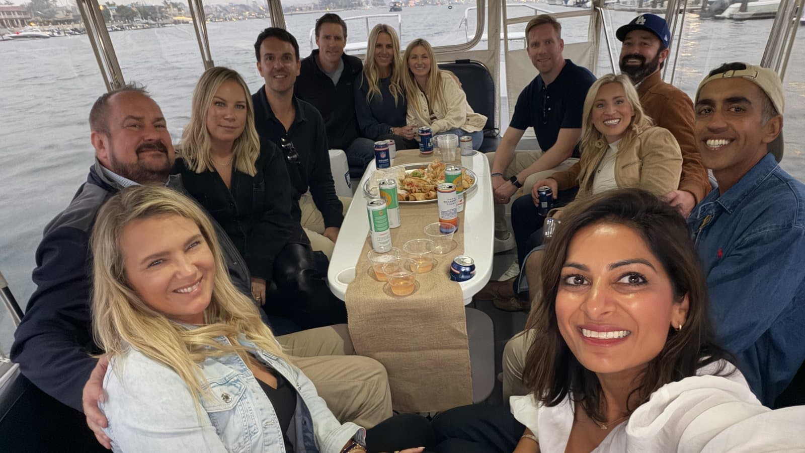 Eastbluff parents around the table aboard a Duffy on Newport Harbor at dusk