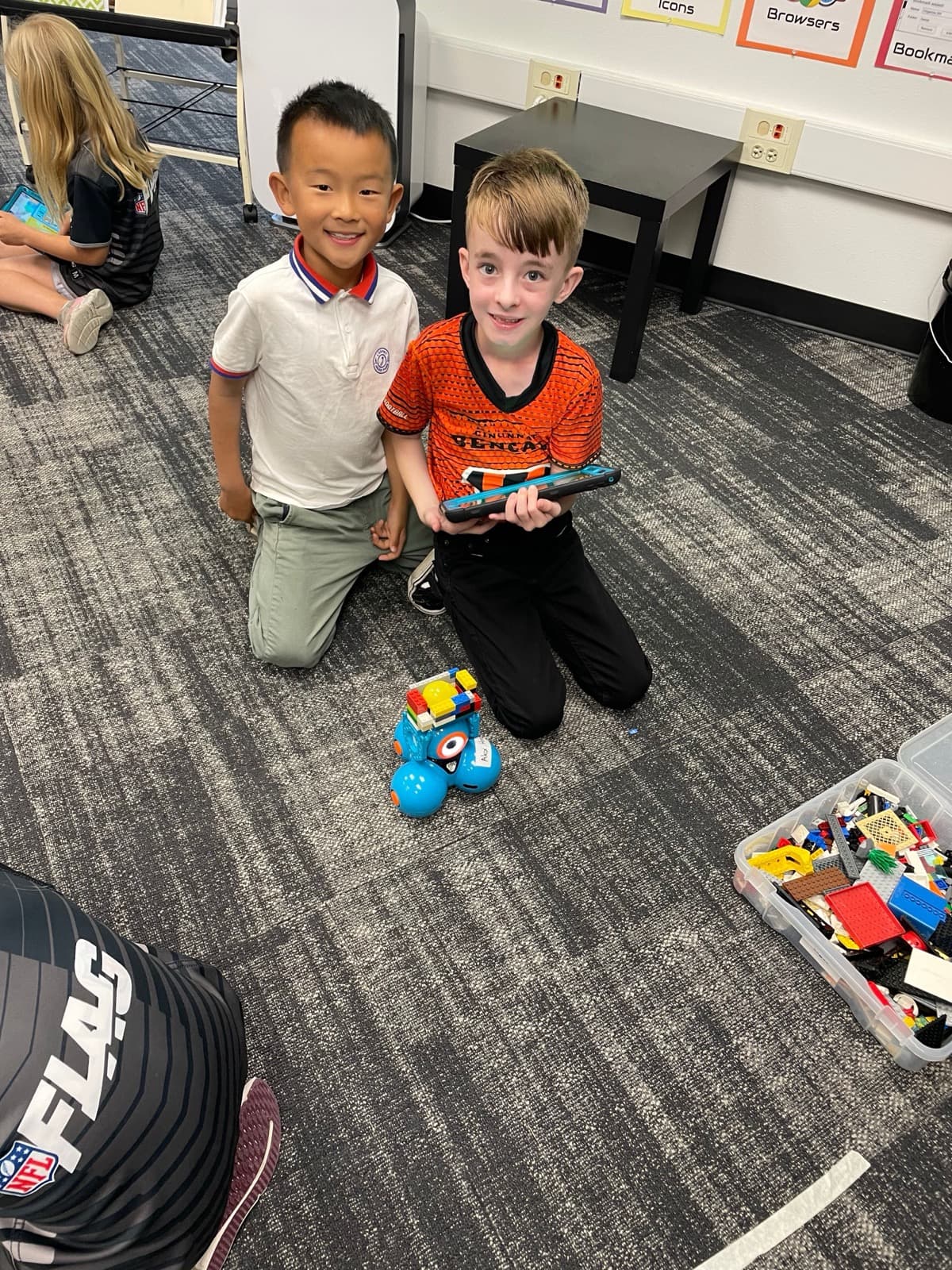Two Eastbluff students programming a robot with a tablet in the Otter Lab